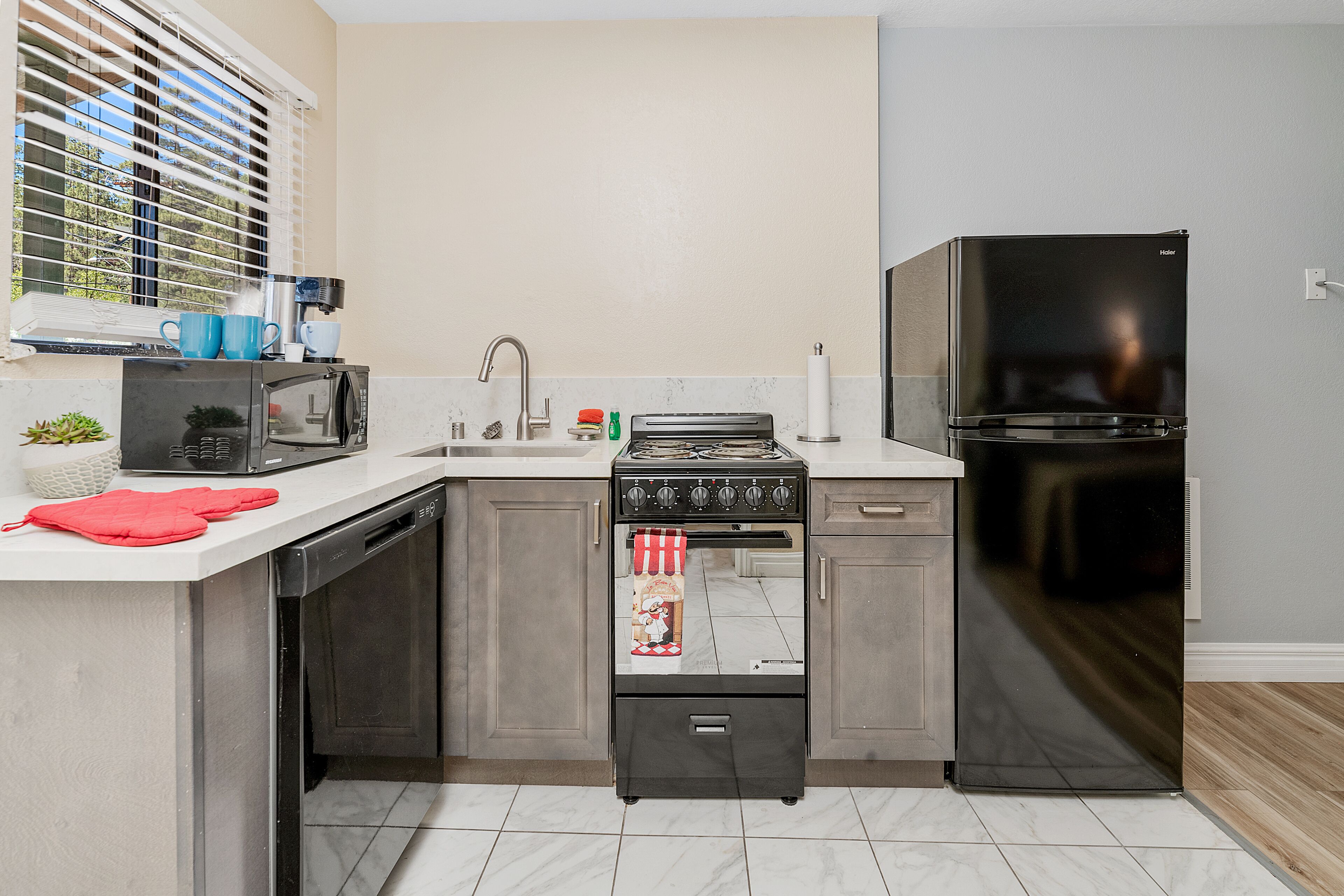 A compact kitchen with a built-in stove, microwave, and refrigerator.