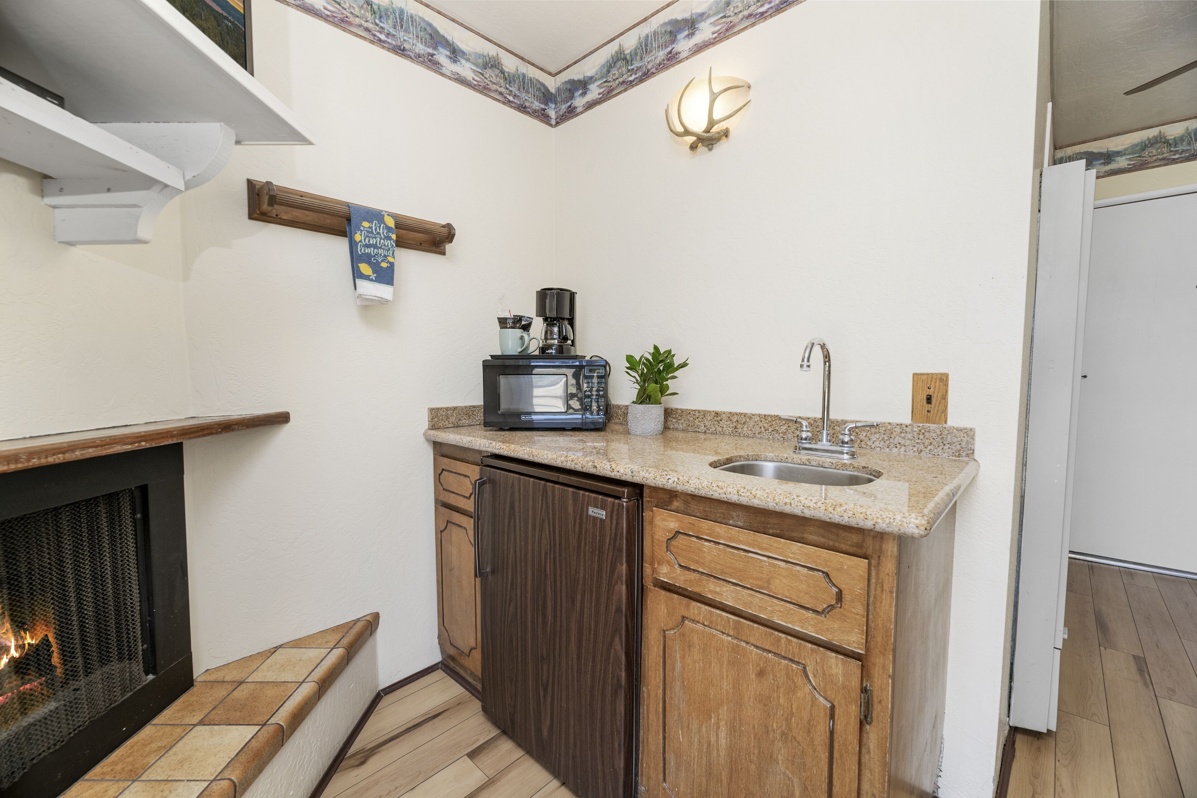 A compact kitchen with a built-in microwave, coffee maker, and sink.