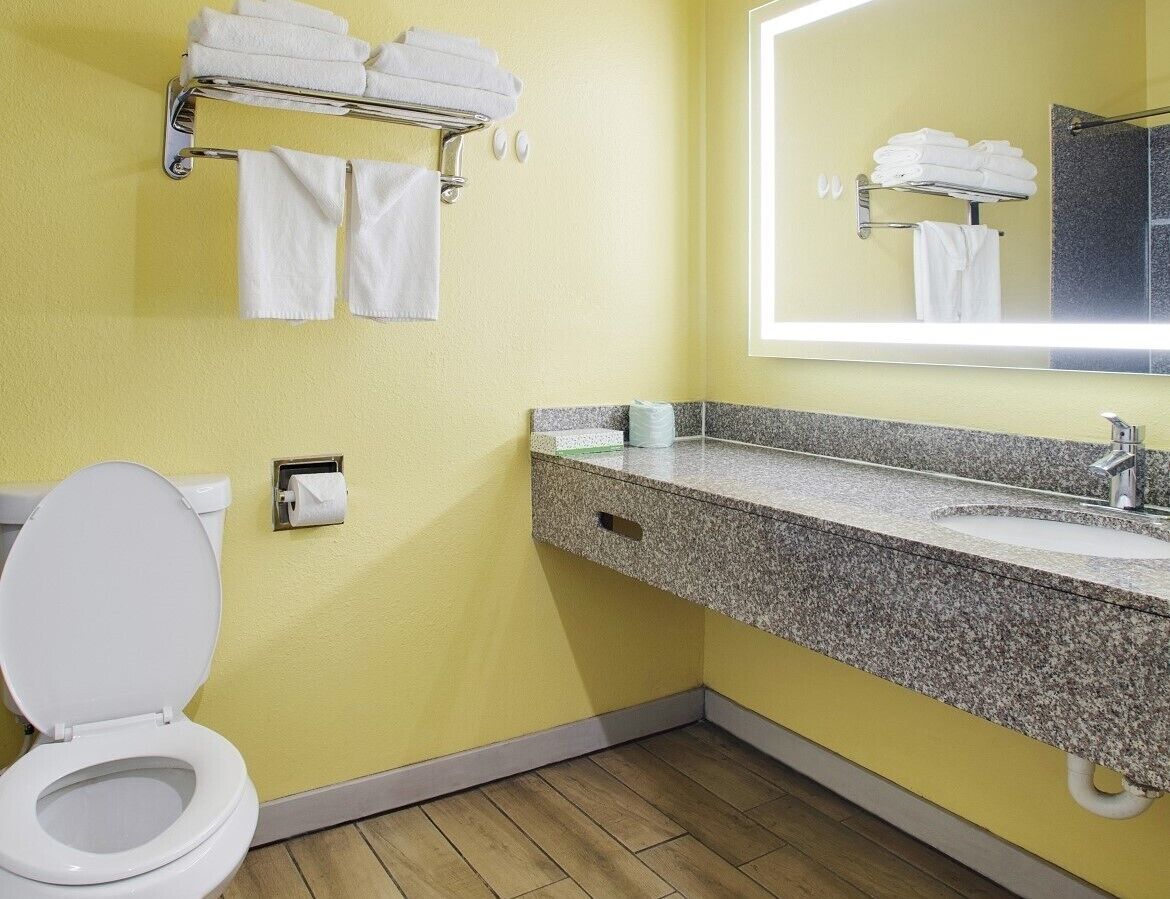 A bathroom with a toilet, sink, and towel rack.