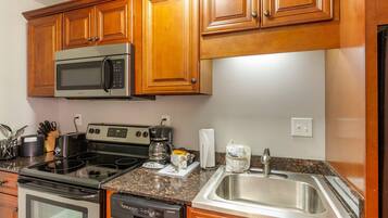 A modern kitchen with wooden cabinets, stainless steel appliances, and granite countertops.
