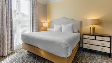 Ein Hotelzimmer mit einem großen Bett, einem Nachttisch mit Lampe und einem gemusterten Boden.