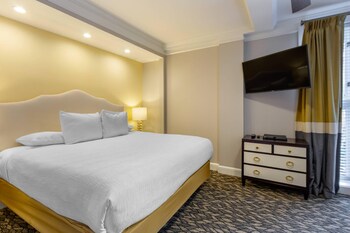 A modern kitchen with white cabinets, stainless steel appliances, and granite countertops. at Church Street Inn Historic Charleston, Ascend Collection Hotel