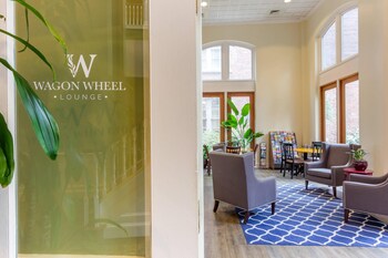 A spacious lobby with a blue patterned carpet, comfortable seating, a reception desk, and large windows allowing natural light. at Church Street Inn Historic Charleston, Ascend Collection Hotel