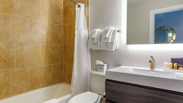 A bathroom with a bathtub, toilet, and sink.