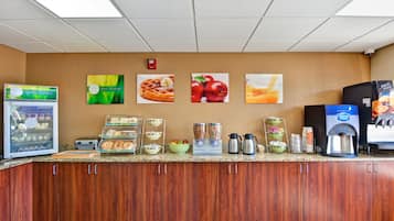 A breakfast bar with a coffee machine, waffle maker, and various food items.