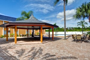 Una piscina al aire libre, sillones reclinables de piscina