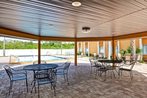 Una piscina al aire libre, sillones reclinables de piscina