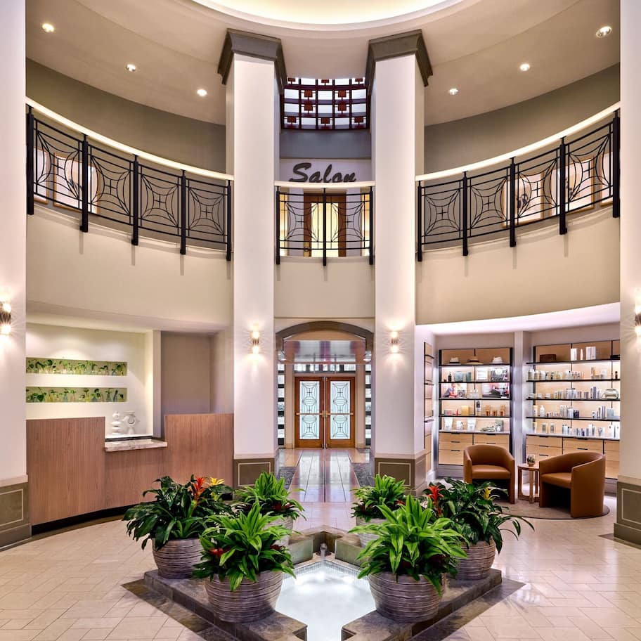 A spacious lobby with a central staircase, a reception area, and a salon.