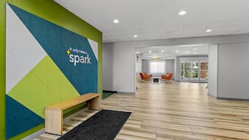 A modern interior with a geometric wall design, a wooden bench, and a herringbone floor pattern.