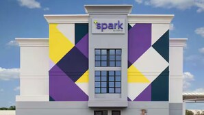 A building with the name 'spark' on the facade, featuring a geometric pattern of triangles and rectangles. - Spark by Hilton Parker Denver SE (Parker)