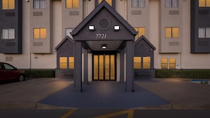 A building with a central entrance, numbered 7721, flanked by two smaller structures. - Days Inn by Wyndham near Kansas Speedway (Kansas City)