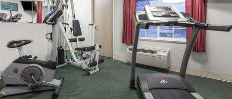 Una sala de gimnàstica amb equip de cardio, una cinta de córrer i una bicicleta estaciónia.