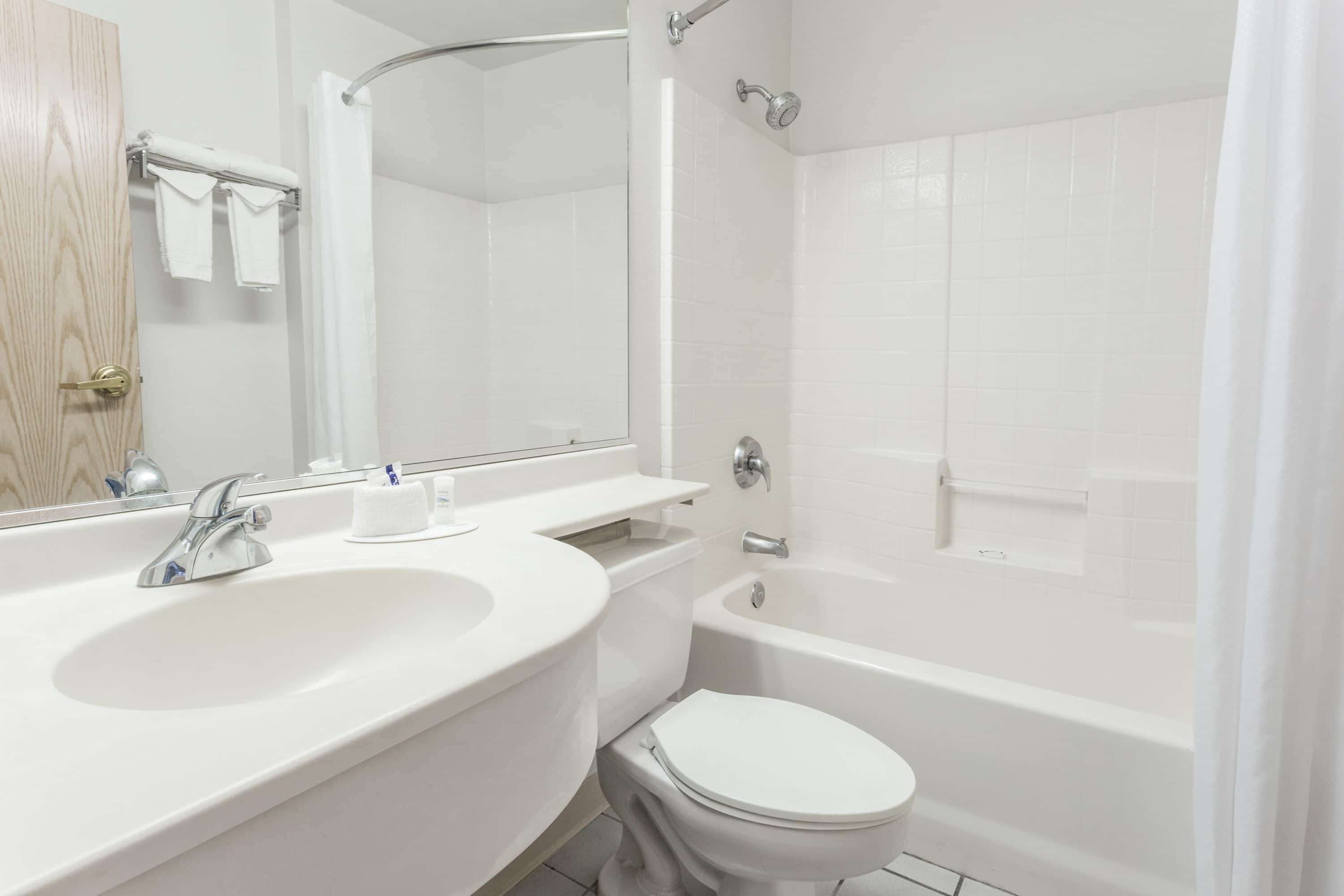 A modern bathroom with a white sink, toilet, and bathtub.