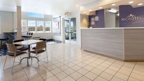 A clean, modern reception area with a reception desk, seating area, and large windows providing natural light.