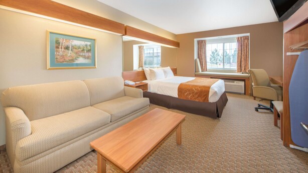 Une chambre d’hôtel avec un canapé, un lit, un bureau et une télévision.