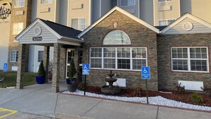 A multi-story hotel with a stone facade, a covered entrance, and handicap parking signs. - Sleep Inn St. Robert-Fort Leonard Wood (St. Robert)