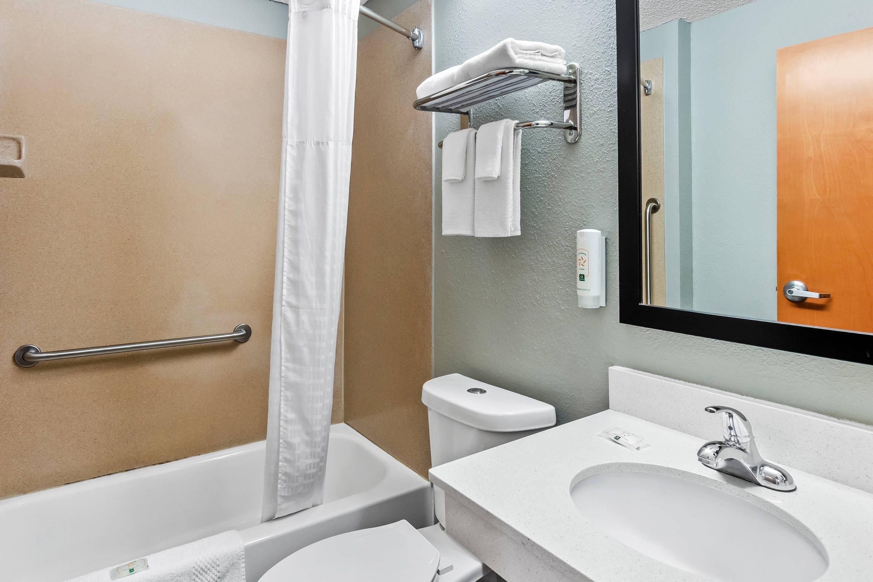 A bathroom with a bathtub, toilet, sink, and a towel rack.