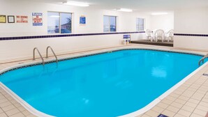 An indoor swimming pool with clear safety signs, a tiled floor, and a seating area with chairs. - Super 8 by Wyndham Monmouth IL (Monmouth)