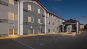 A multi-story hotel with a covered entrance, handicap parking, and a welcoming facade.