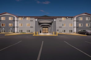 A modern hotel with a symmetrical facade, multiple windows, and a central entrance. - Red Roof Inn Huntsville, AL (Huntsville)