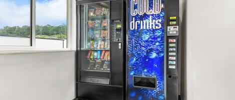 A vending machine with a 'COLD drinks' sign and a window display.