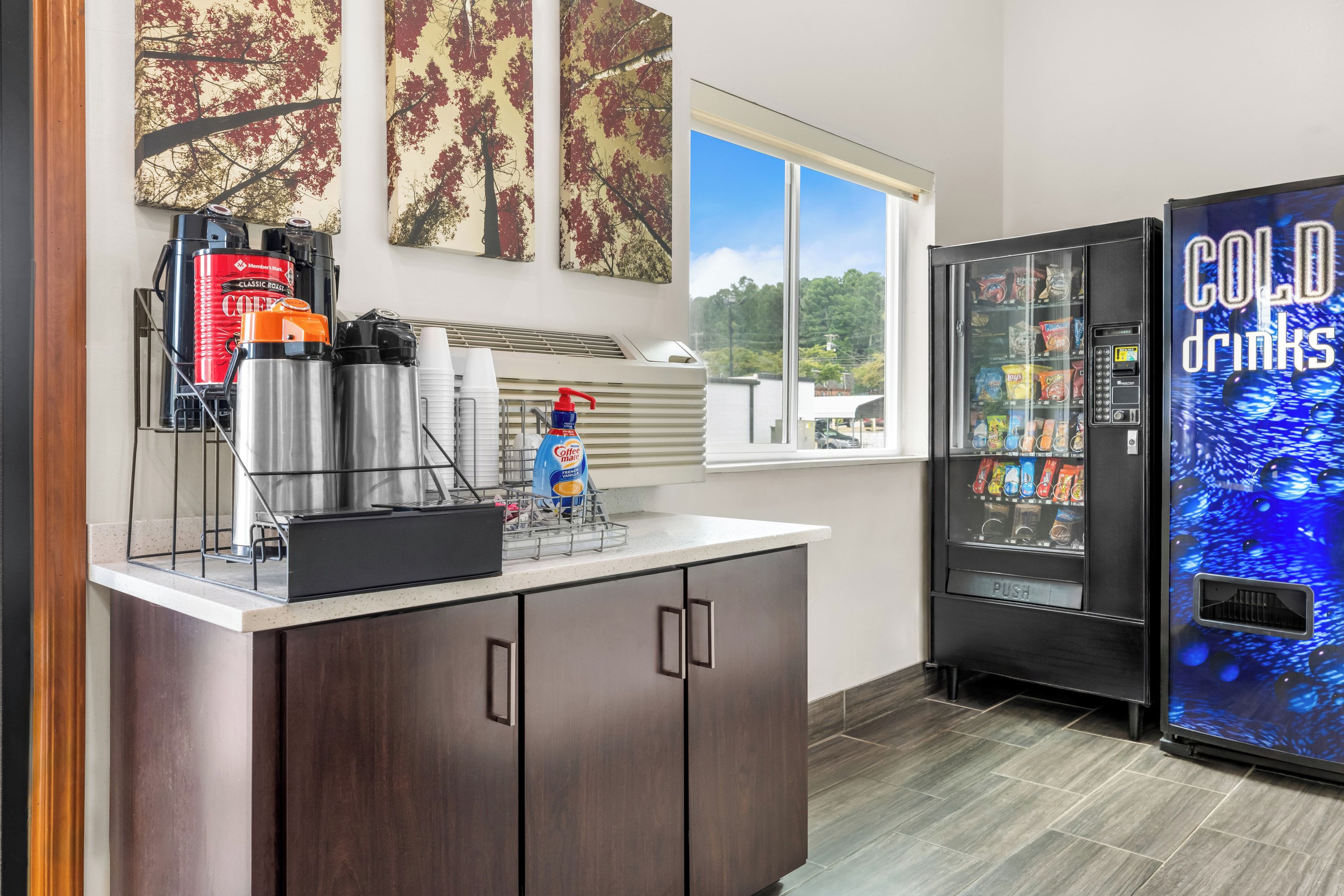 A kitchenette with a coffee machine, a water dispenser, and a refrigerator vending machine.