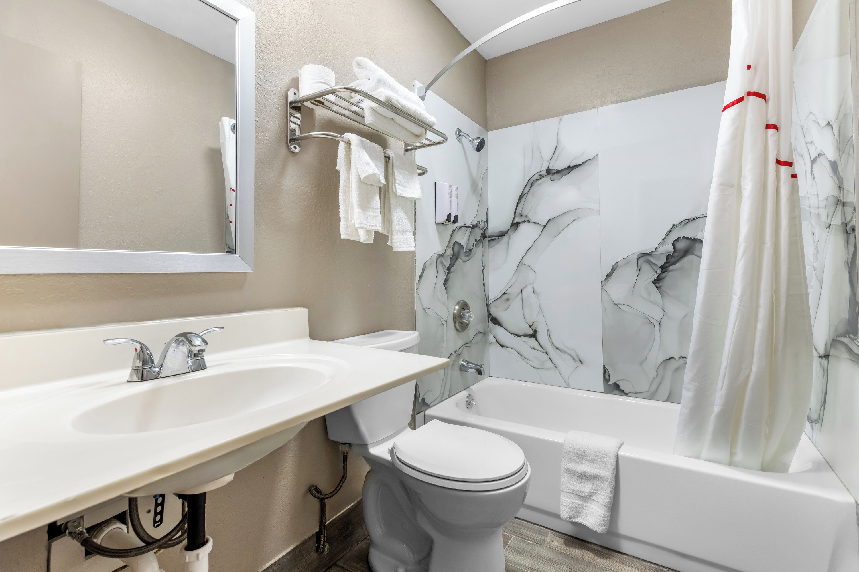 A modern bathroom with a white sink, a toilet, and a bathtub.