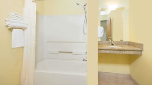 A bathroom with a bathtub, shower, and sink. - Super 8 by Wyndham Moriarty (Moriarty)