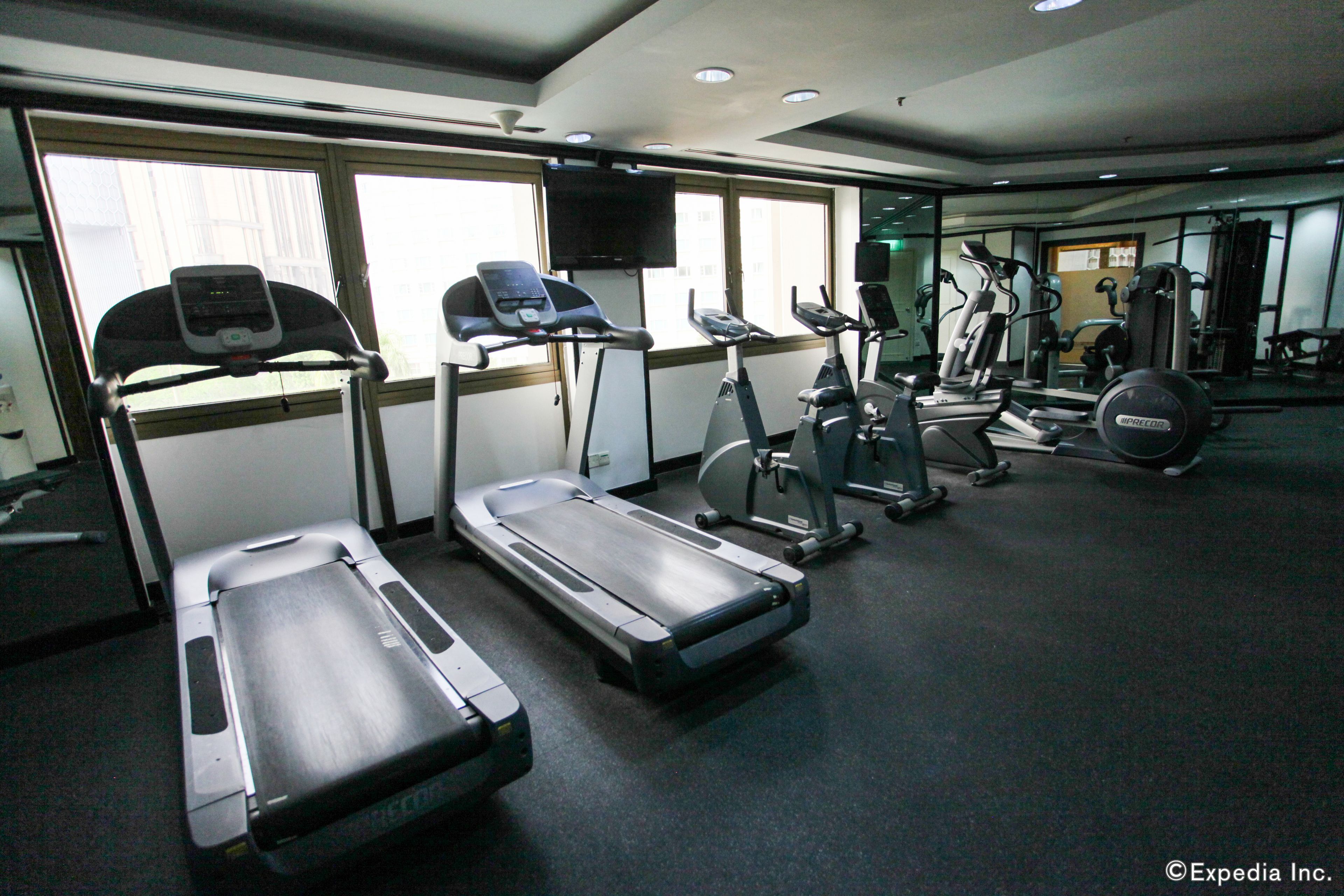 A gym with treadmills, elliptical machines, and weight equipment.