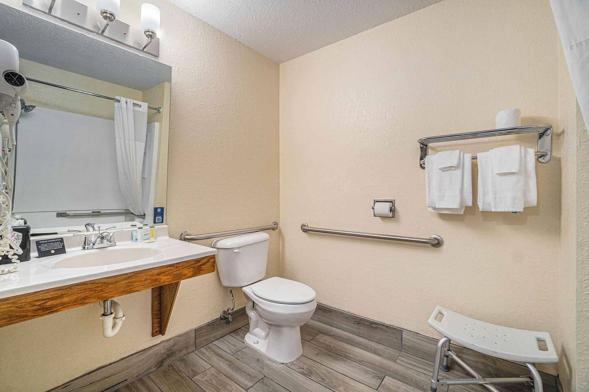 A bathroom with a sink, toilet, and a shower area.