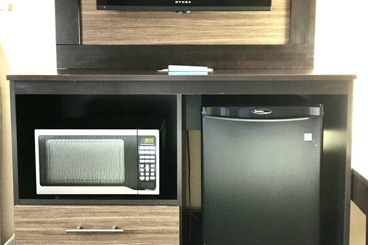 A kitchen with a microwave, a refrigerator, and a built-in oven.