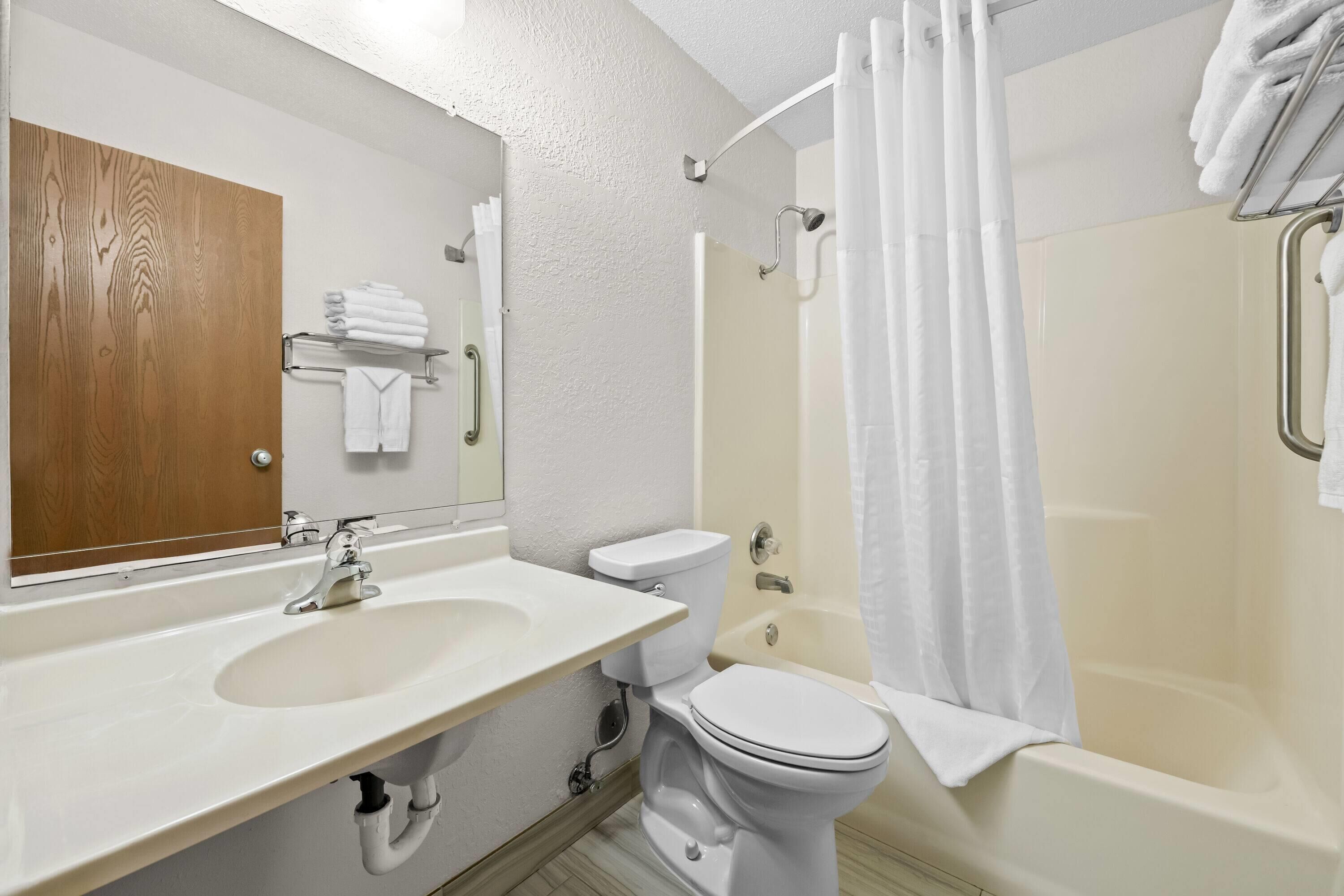 A bathroom with a sink, toilet, and bathtub.