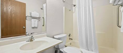A bathroom with a sink, toilet, and bathtub.