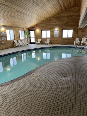 Una piscina techada, sillones reclinables de piscina