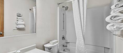 A bathroom with a sink, toilet, and bathtub.
