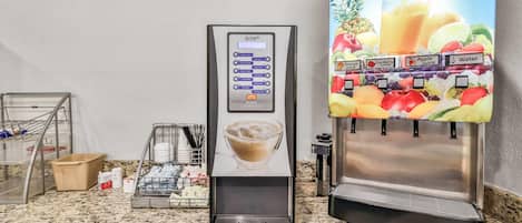 Una máquina de café y un dispensador de jugo sobre una encimera de cocina.