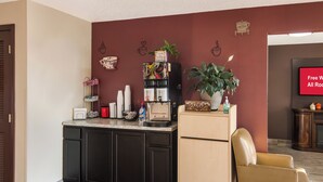 Una cocina equipada con refrigerador, cafetera y una planta en la encimera.