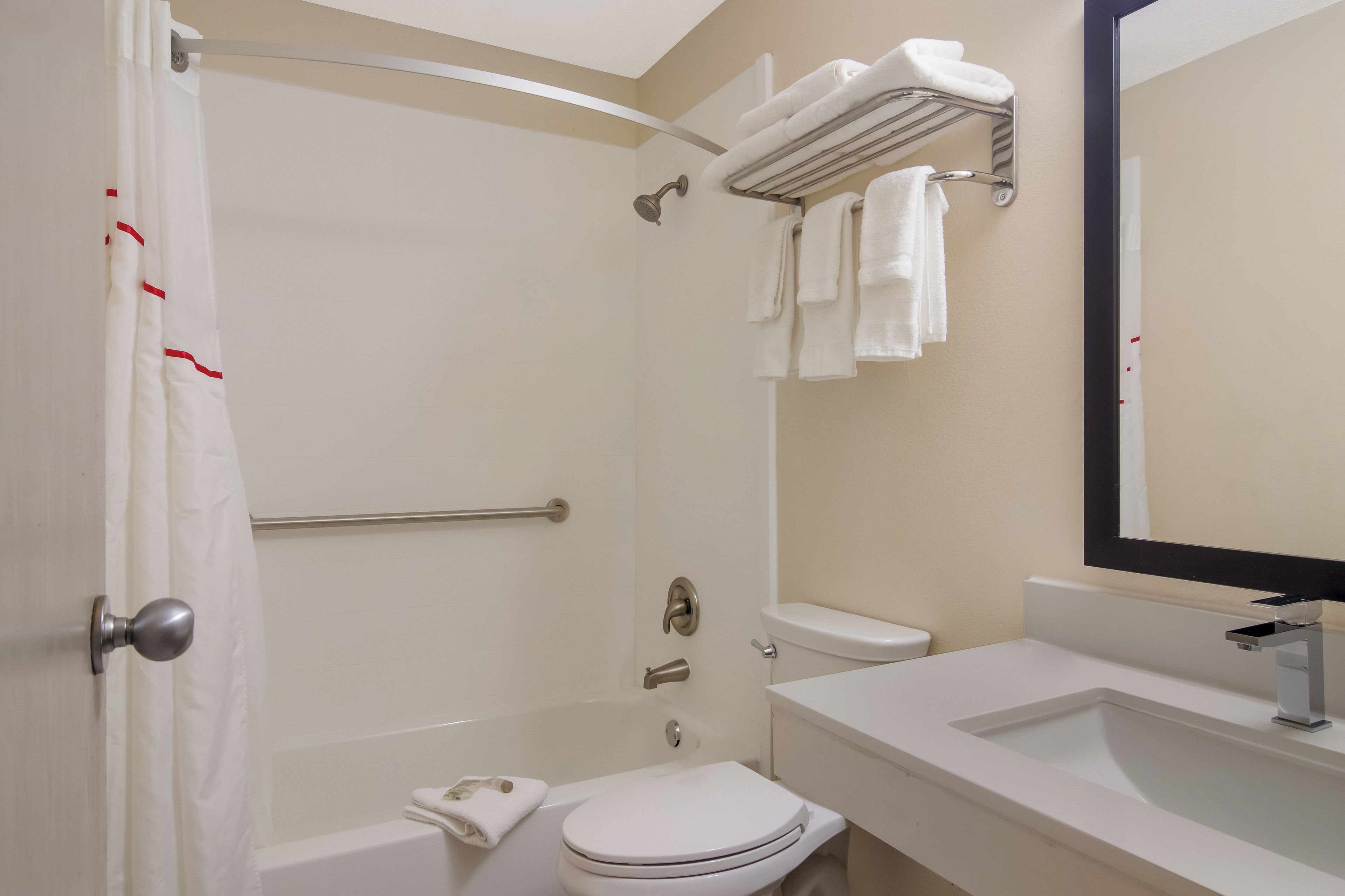 A bathroom with a shower, toilet, and sink.