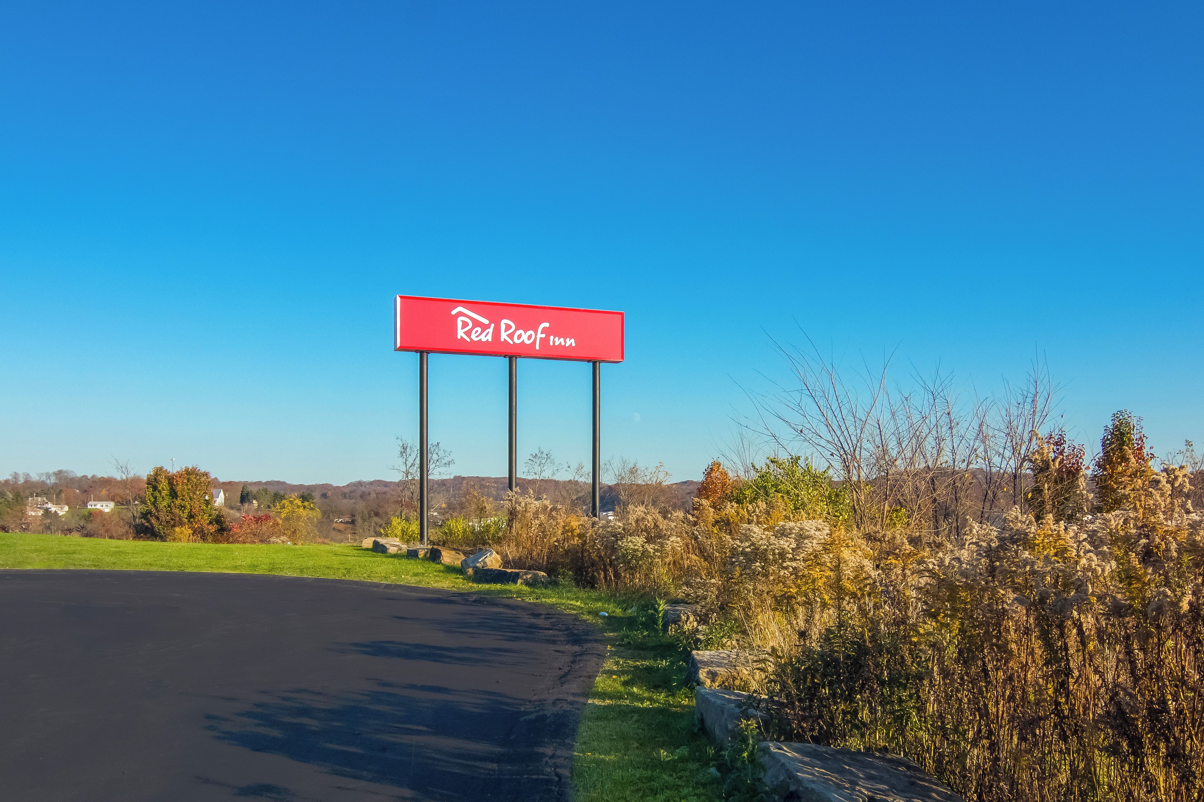 A Red Roof Inn sign on a clear day.