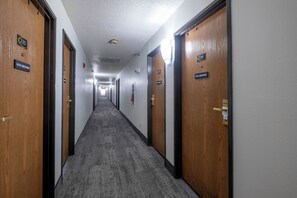 A hotel corridor with doors numbered 235 and 234, a 'NON SMOKING' sign, and a 'PRIVACY PLEASE' sign on the door handle. - Red Roof Inn Greensburg (Greensburg)