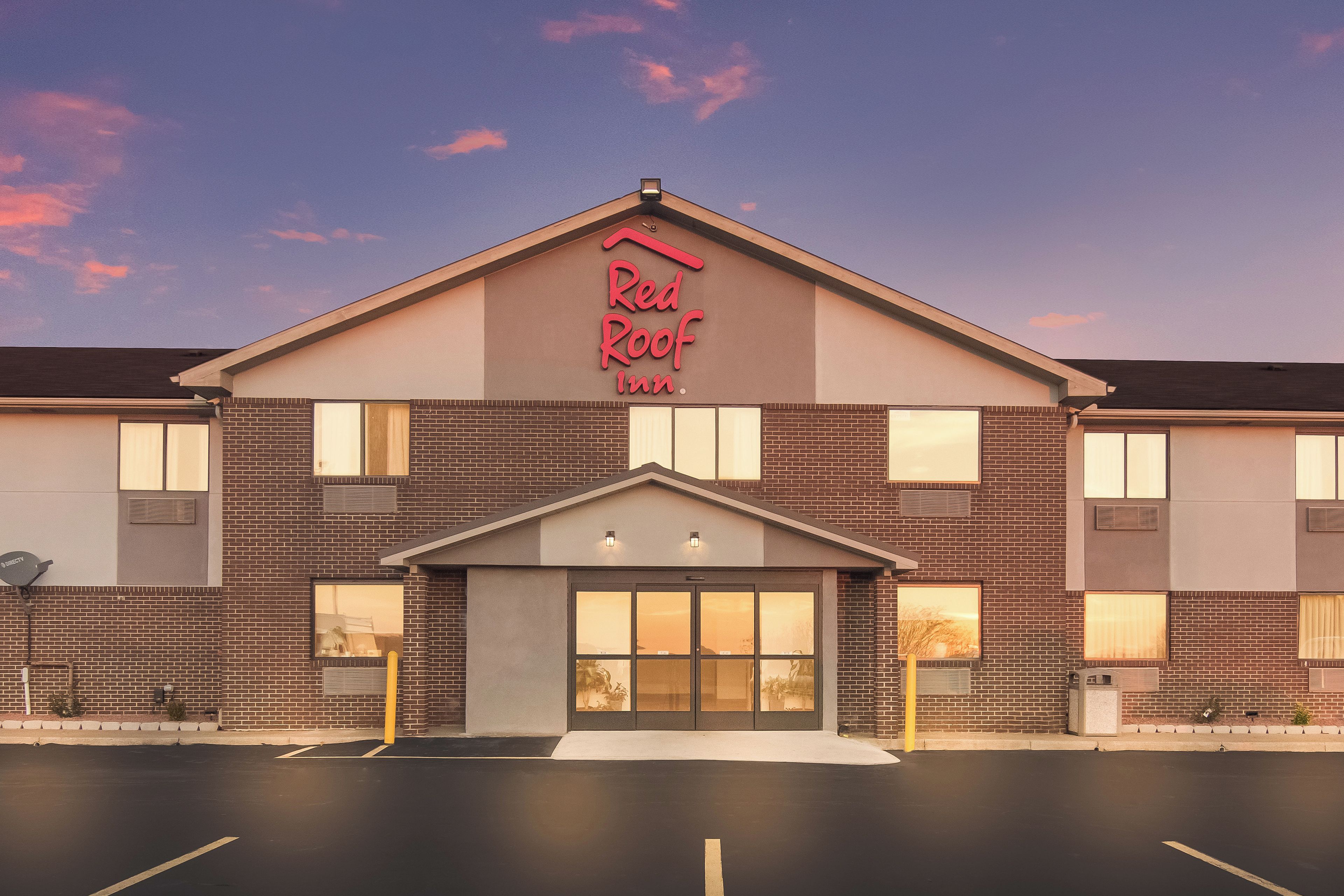 Et Red Roof Inn hotel med facade i mursten, store vinduer og et fladt tag.
