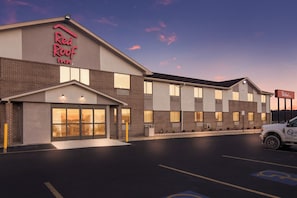 A Red Roof Inn with a brick facade, large windows, and a parking lot with a handicapped parking space. - Red Roof Inn Greensburg (Greensburg)