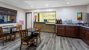 Une chambre d’hôtel avec un coin repas, une kitchenette et une vue sur l’extérieur.