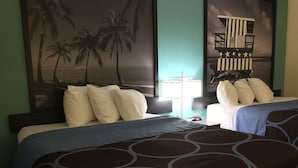A hotel room with two beds, a nightstand, a lamp, and a wall mural. - Super 8 by Wyndham Clearwater/St. Petersburg Airport (Clearwater)