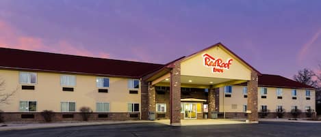 Un Red Roof Inn con un edificio de dos pisos, un acceso cubierto y un estacionamiento.