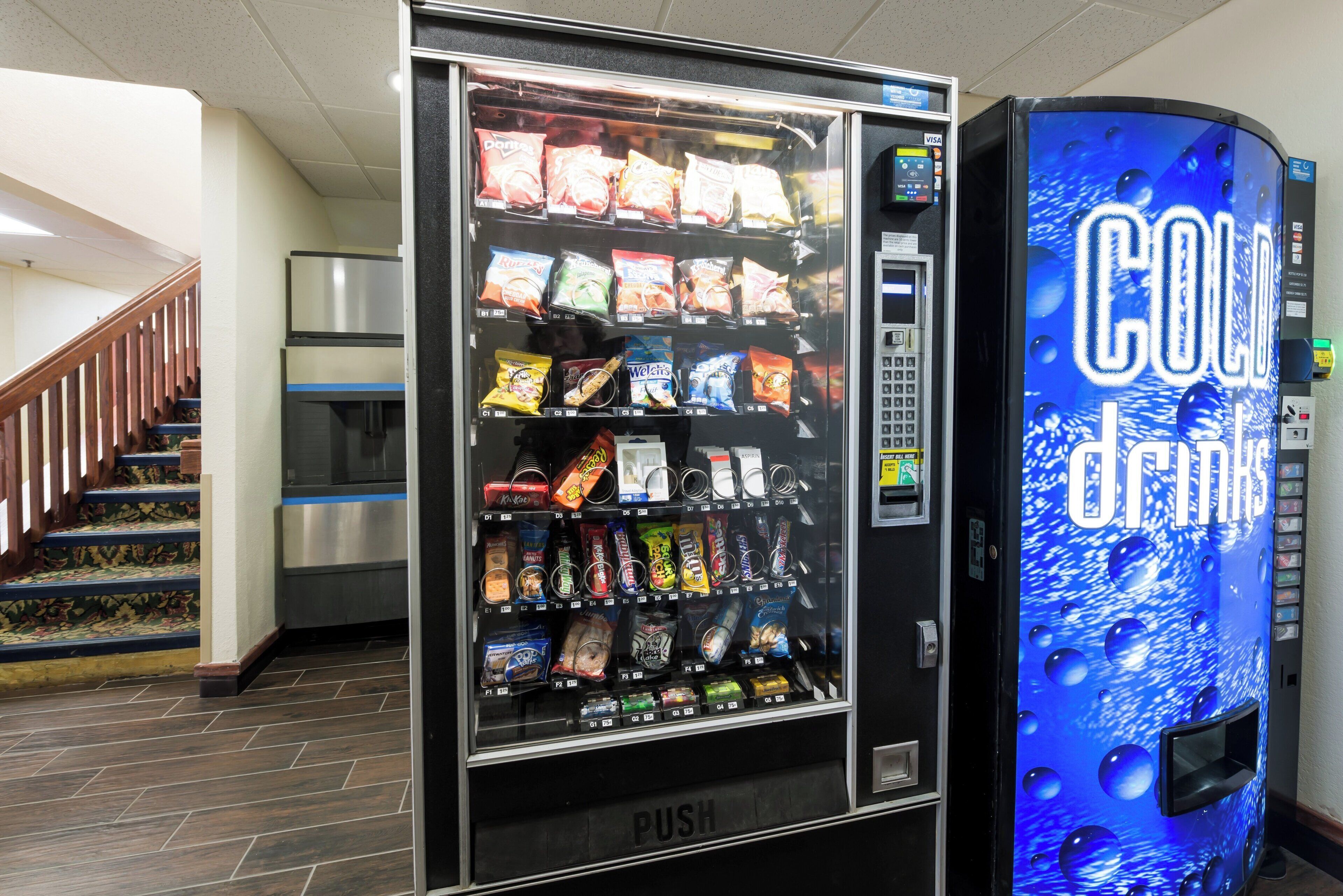 Máquina automática com variedade de lanches e refrigeradores Coca-Cola.