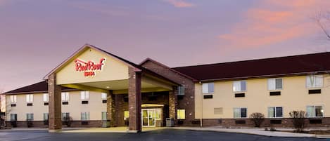 A Red Roof Inn with a covered entrance, multiple windows, and a parking lot.