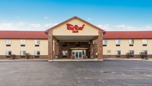 A two-story building with a red roof and beige siding, featuring a sign that reads 'Pad Room Inn.' - Red Roof Inn Auburn (Auburn)