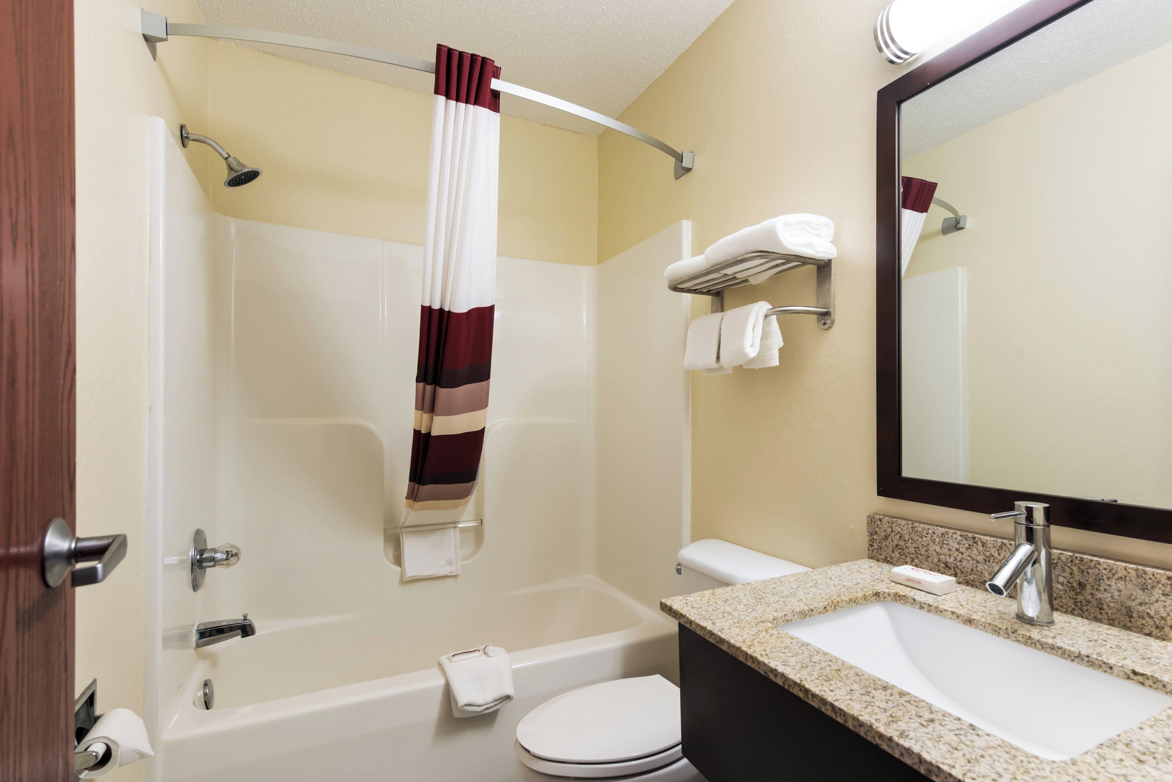 Une salle de bain équipée d’une baignoire, de toilettes, d’un lavabo et d’un miroir.