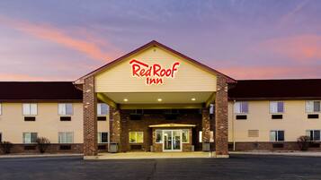 Un Red Roof Inn con fachada de ladrillo, techo plano y una entrada amplia.